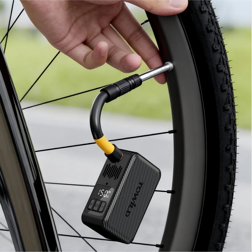 A cyclist connecting the TOWILD A15 electric bike pump using the flexible extension hose. The hands-free design protects the delicate Presta valve core while inflating to 150 PSI.