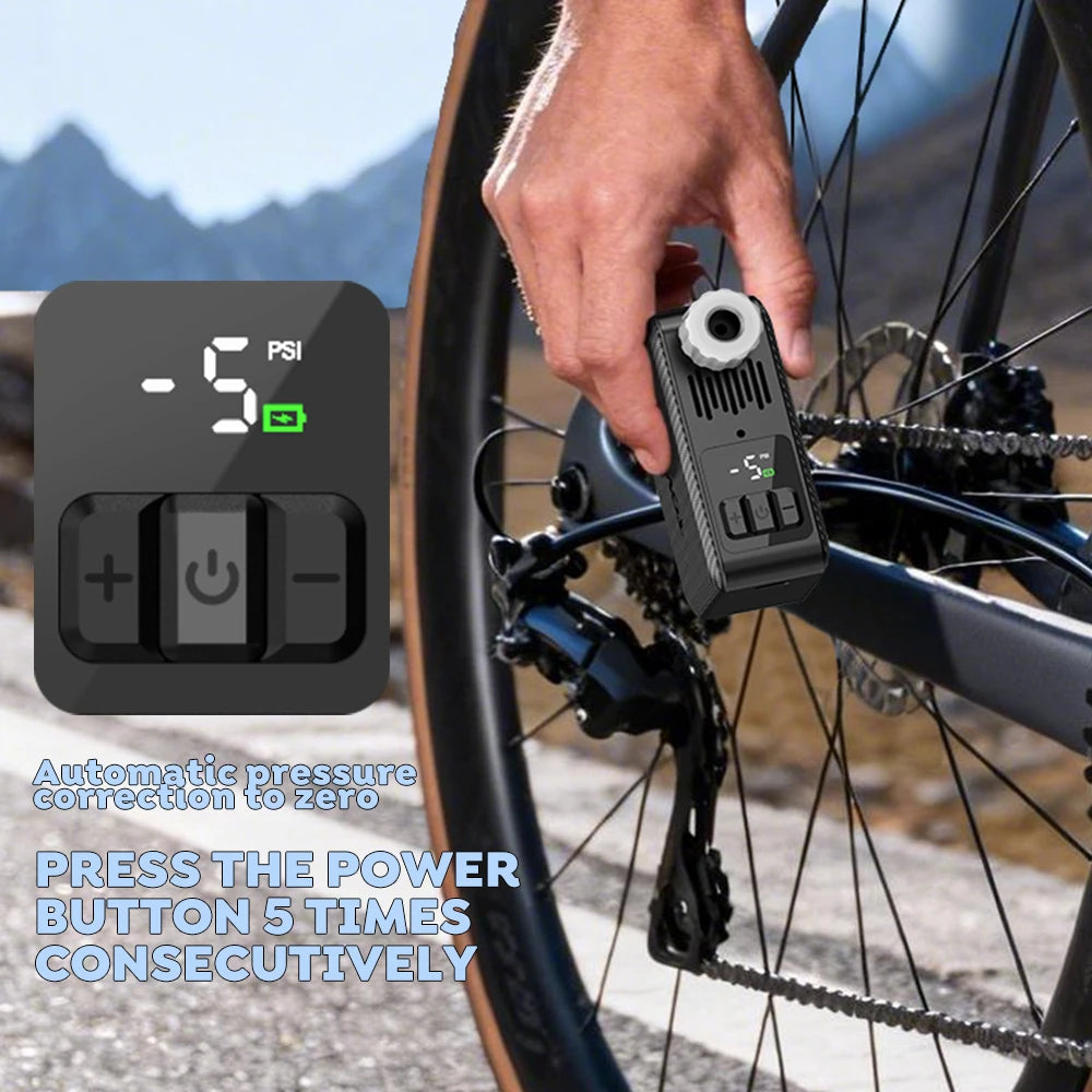 The TOWILD A15 smart bike pump displaying a -5 PSI reading in a mountainous high-altitude setting. On-screen text instructs: Automatic pressure correction to zero, PRESS THE POWER BUTTON 5 TIMES CONSECUTIVELY.
