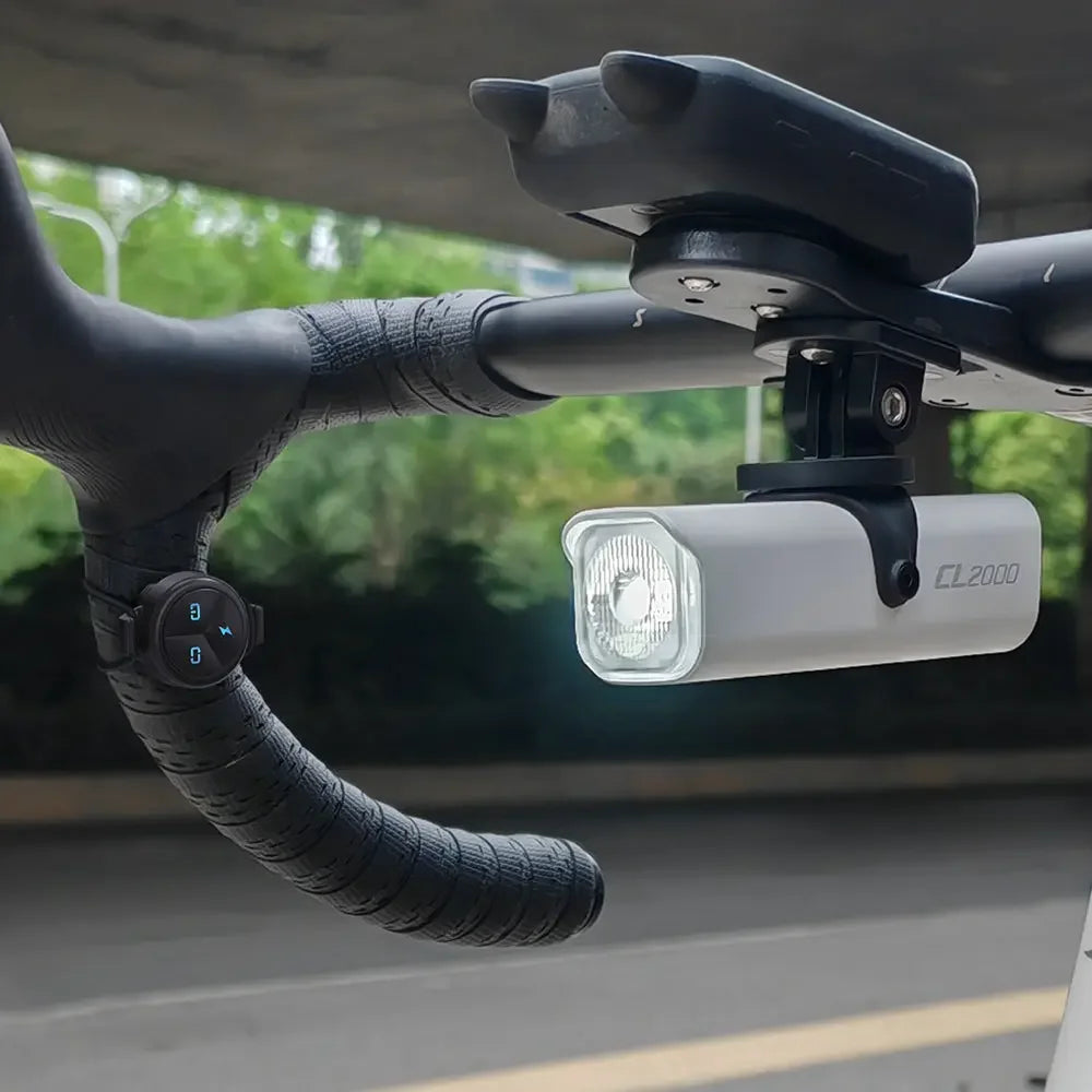 A cyclist using the TOWILD ALC-01 remote on their drop bars to safely control a TOWILD CL2000 front bike light.