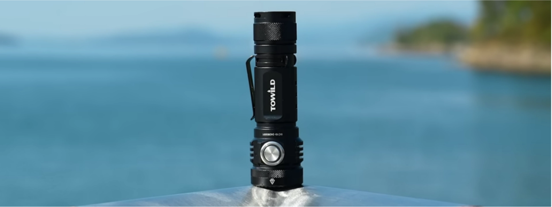 Video thumbnail for Towild BC10 EDC flashlight. Shows the 4000-lumen torch standing upright against a coastal outdoor background, demonstrating its rugged build quality and IPX8 waterproof suitability for camping and adventures.
