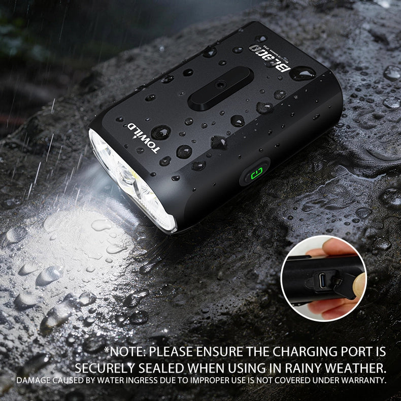 TOWILD BL900 road bike light performing reliably in heavy rain, demonstrating its IPX6 waterproof capability and securely sealed Type-C charging port.