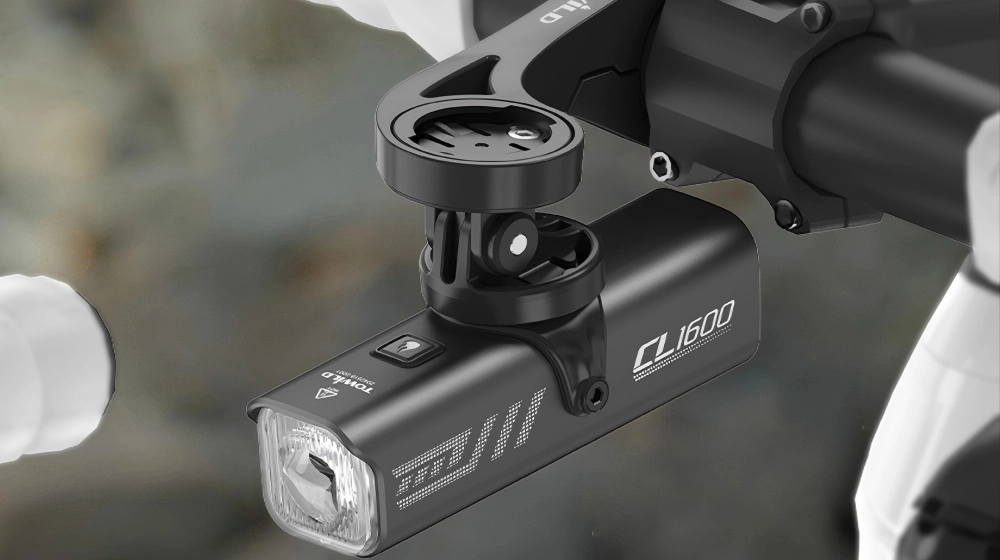 TOWILD CL1600 under-mounted bike light attached via GoPro adapter beneath a Garmin out-front mount, saving handlebar space for MTB riders.