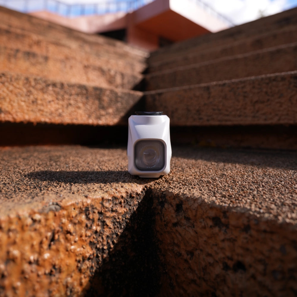 Towild DL1200S white edition placed on outdoor stairs. Highlights the compact, stylish design and premium build quality suitable for urban and road cycling.