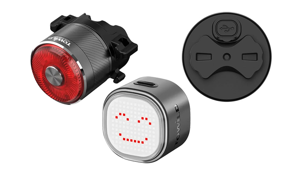 Showcasing the versatility of the TOWILD Smart Tail Light series. Pictured is the premium aluminum TL05, highlighting its integrated Garmin-style quarter-turn mount for compatibility with various brackets, alongside the innovative TL08 displaying a custom pixel emoji via its app. A close-up also reveals the modern USB-C charging port common to the series.