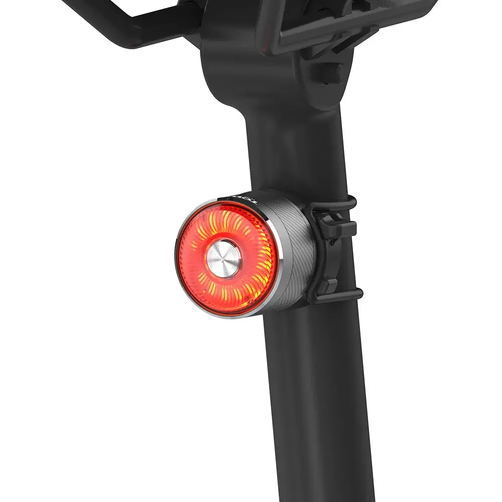 A bright, active TOWILD TL05 aluminum rear light providing high visibility on a bike seatpost.