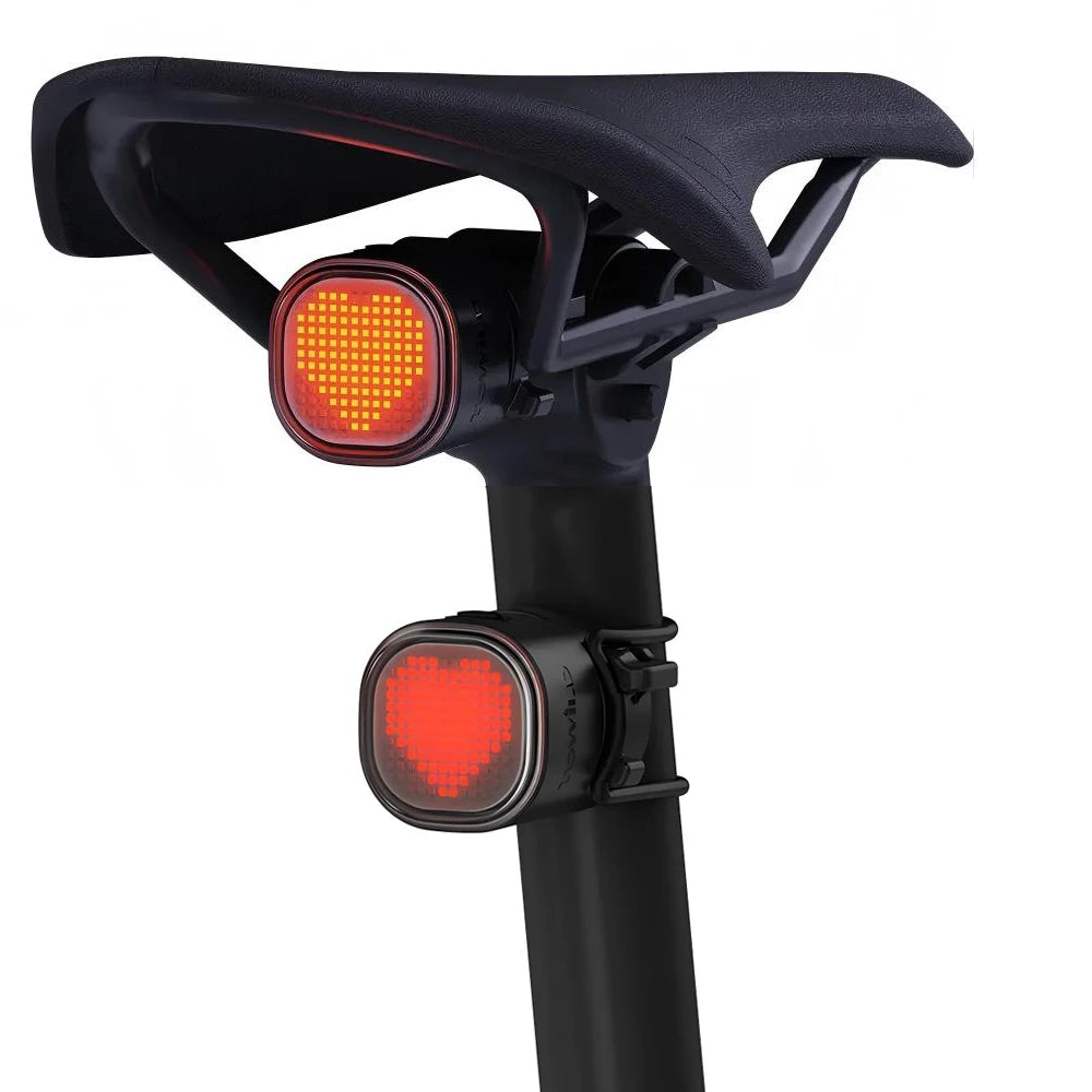Two TOWILD TL08 DIY programmable bike tail lights demonstrating versatile mounting, one under the saddle and one on the seat post, both displaying custom heart animations.