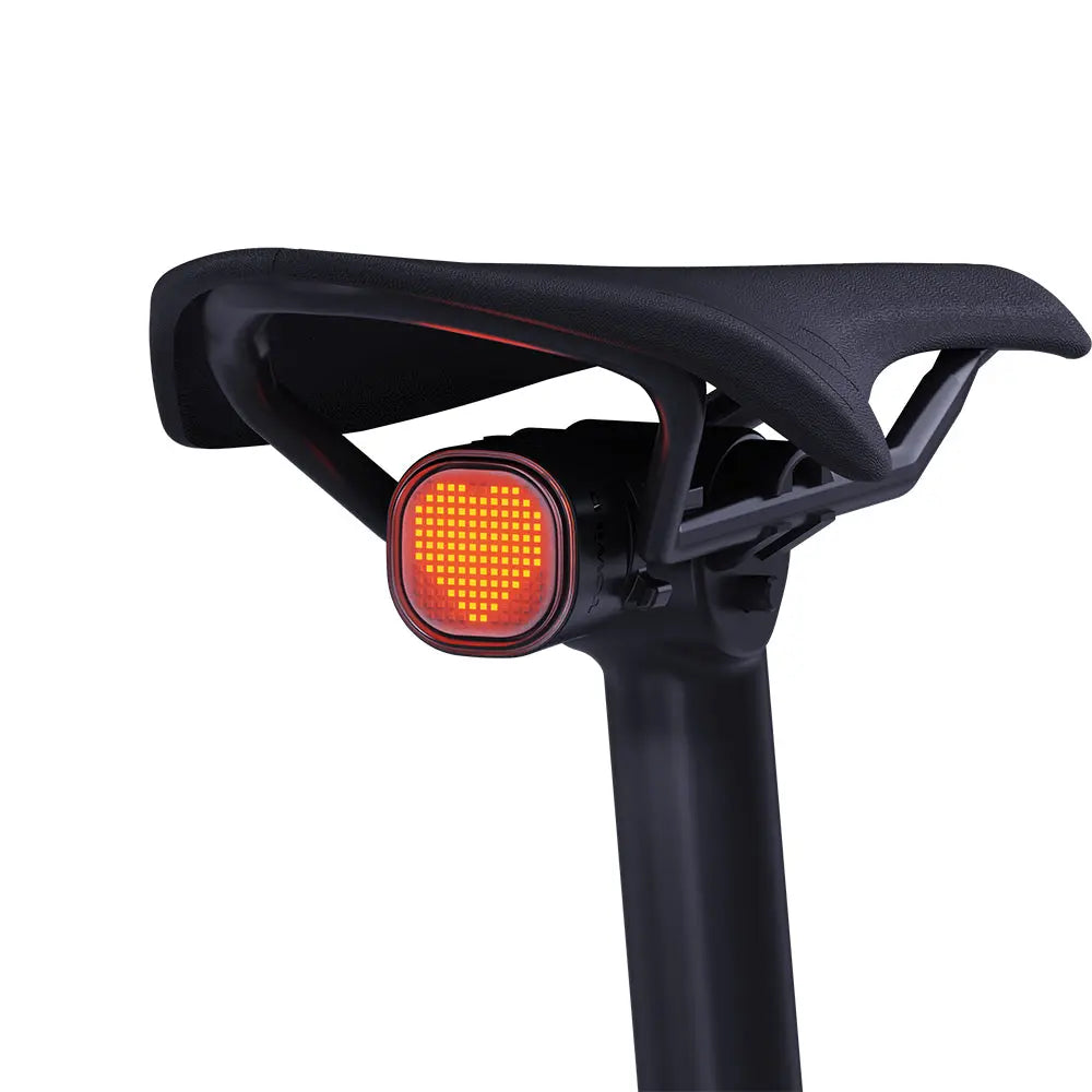 TOWILD TL08 smart tail light mounted under a bicycle saddle and displaying a glowing red heart pixel animation.