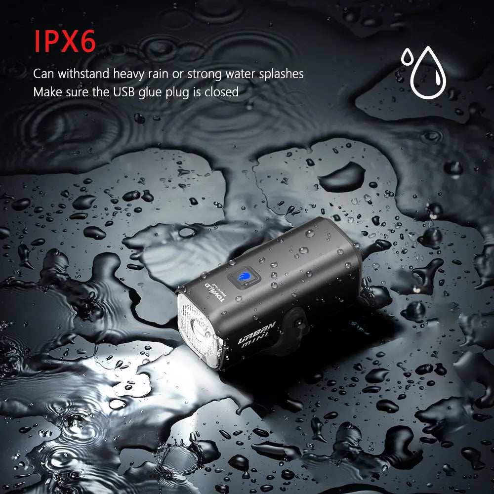 The TOWILD Urban Mini bike light shown being splashed with water, demonstrating its IPX6 waterproof rating for all-weather riding.